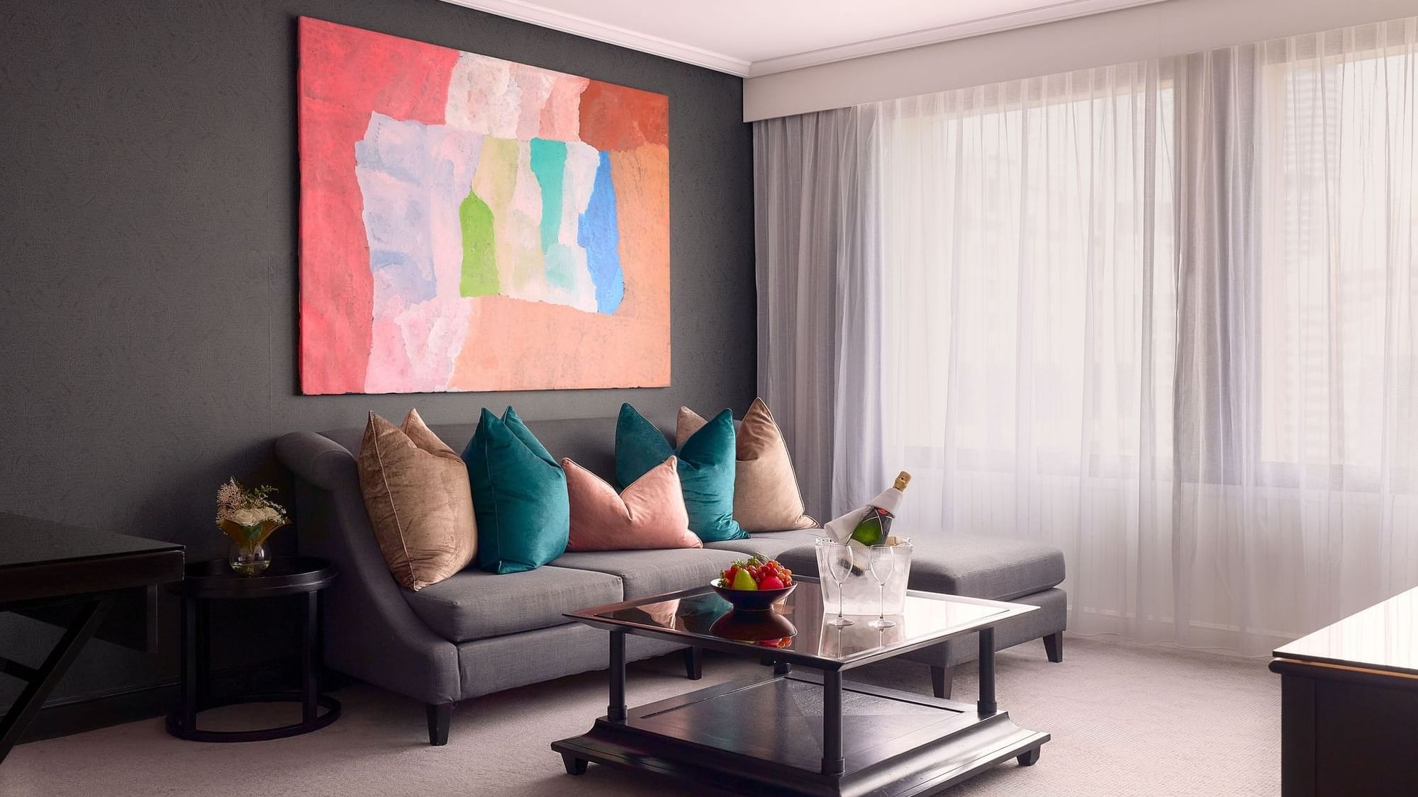 Living area with wall art and plush seating in Signature Suite at Sofitel Brisbane Central