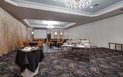 Meeting space set with buffet table and banquet rounds.