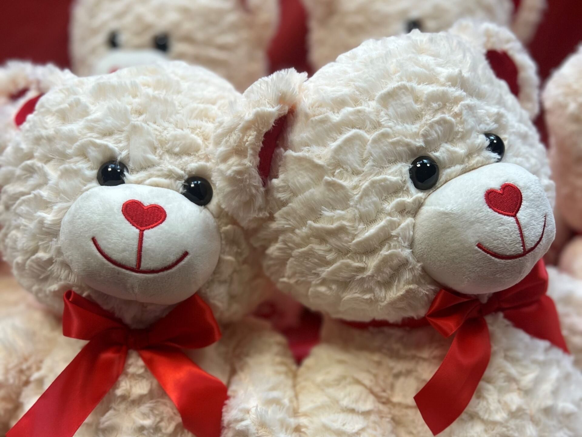 four white teddy bears smiling with red nose
