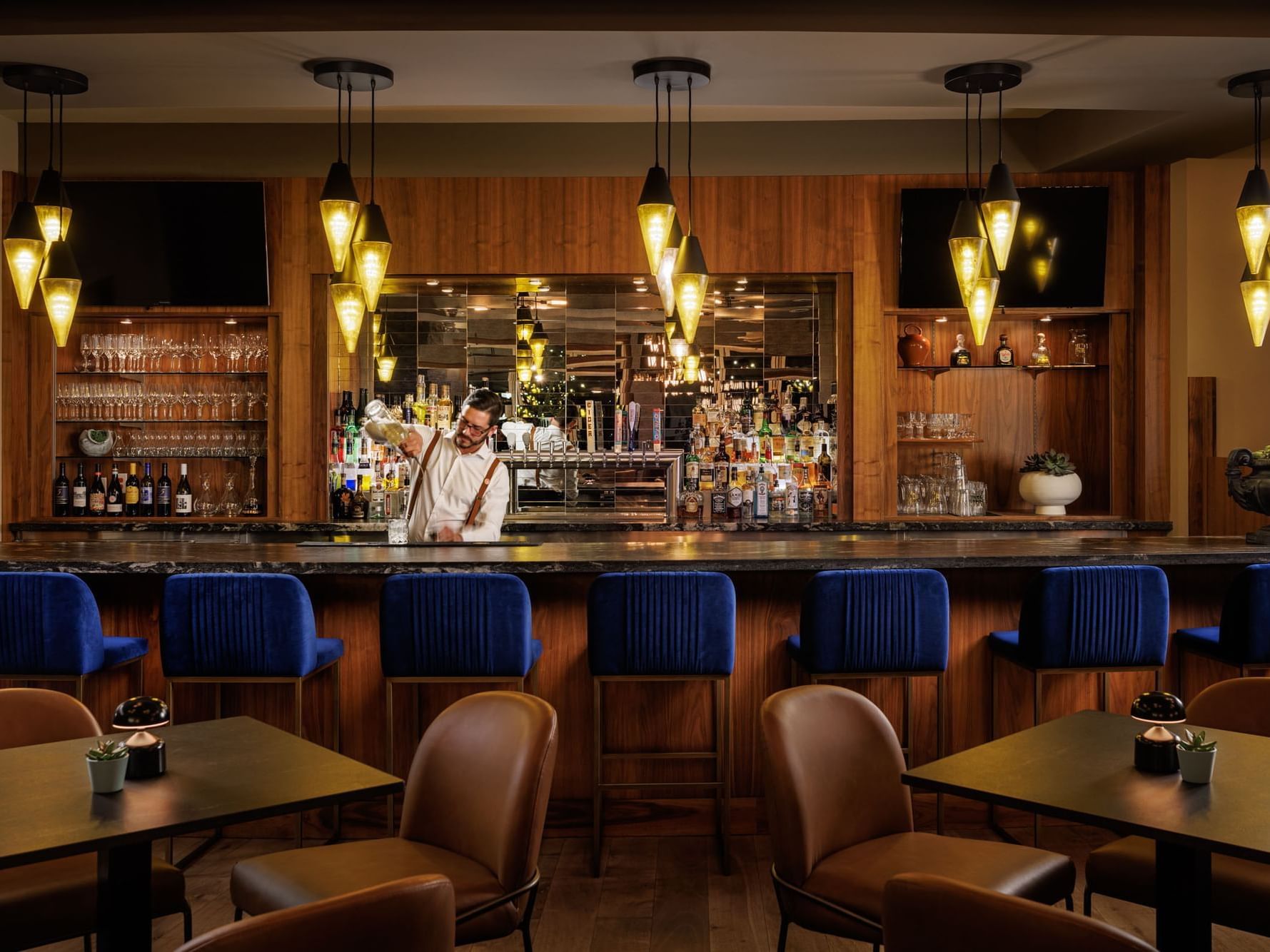 A bartender making drinks by the bar counter at Hotel Eldorado