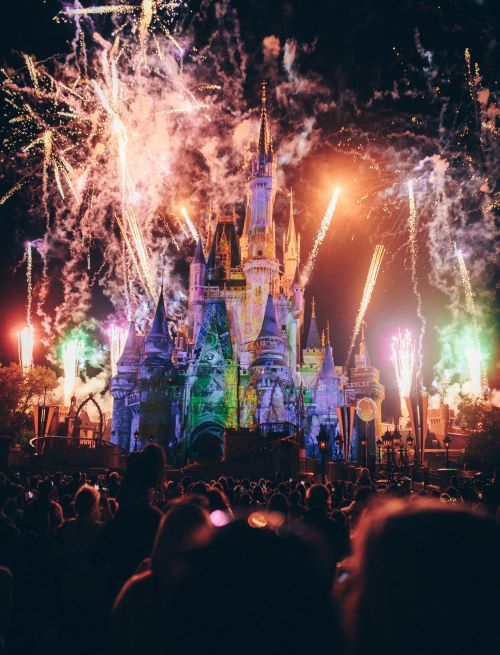 A nighttime image of fireworks and smoke surrounding Cinderella's Castle at Disney's Magic Kingdom. Instead of fighting the crowds at the main viewing areas of the fireworks show, consider watching it from a quieter vantage point.