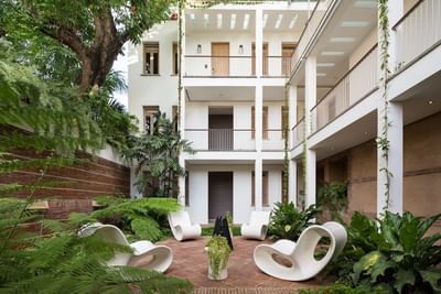 Serene courtyard featuring modern chairs surrounded by lush greenery at Billini Hotel Historic Luxury