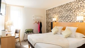 Bedroom arrangement at Hotel Le Pavillon of Originals Hotels