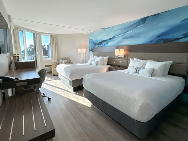 Hotel guestroom with two queen beds and a blue wall mural