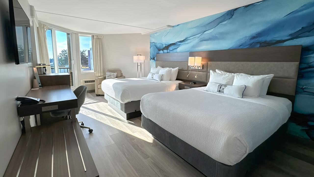 Hotel guestroom with two queen beds and a blue wall mural