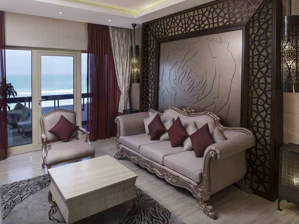 A sitting area with a sea view in Wedding Suite at Ajman Hotel