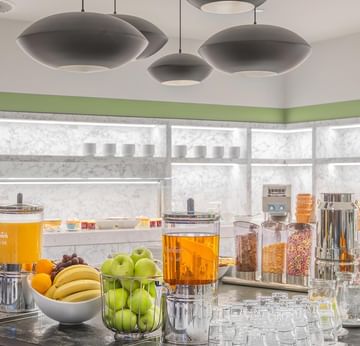 Frühstücksbuffet mit Getränken und frischem Obst im Restaurant des Titanic Comfort Kurfürstendamm.