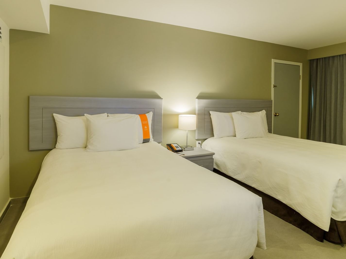 2 Double Deluxe room featuring two comfortable queen beds, modern grey headboards, and soft lighting at Real Inn Mexicali