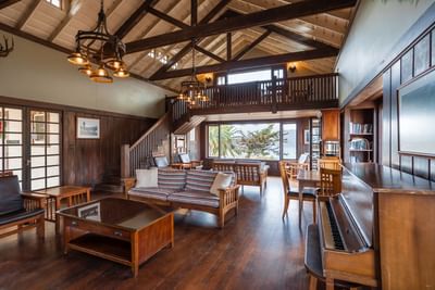 Livingroom area with vintage furniture & a piano in Banning House Lodge, Catalina Island Company