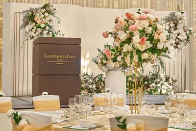 The elegantly decorated main table with a Goodwood Park Hotel podium and stunning pink and white floral centerpieces