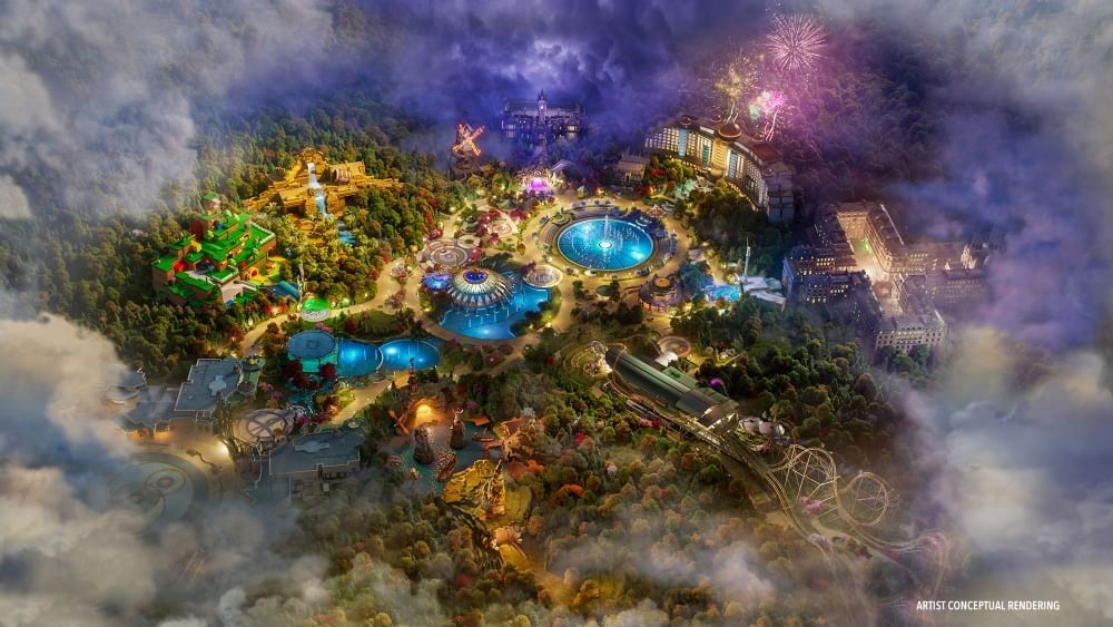 A conceptual rendering of EPIC Universe as an aerial shot, looking down on three central bodies of water and outlying areas with coasters, fireworks, and trees. 