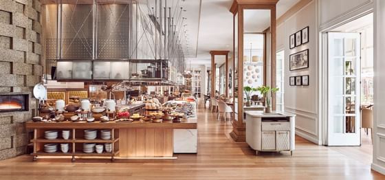 Opera interior featuring a buffet area with various dishes, and wooden floors at Park Hyatt Saigon