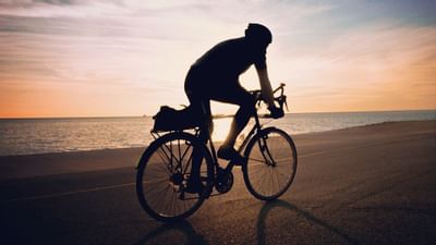 A guy riding a cycle in Falmouth Beach near Falmouth Tides