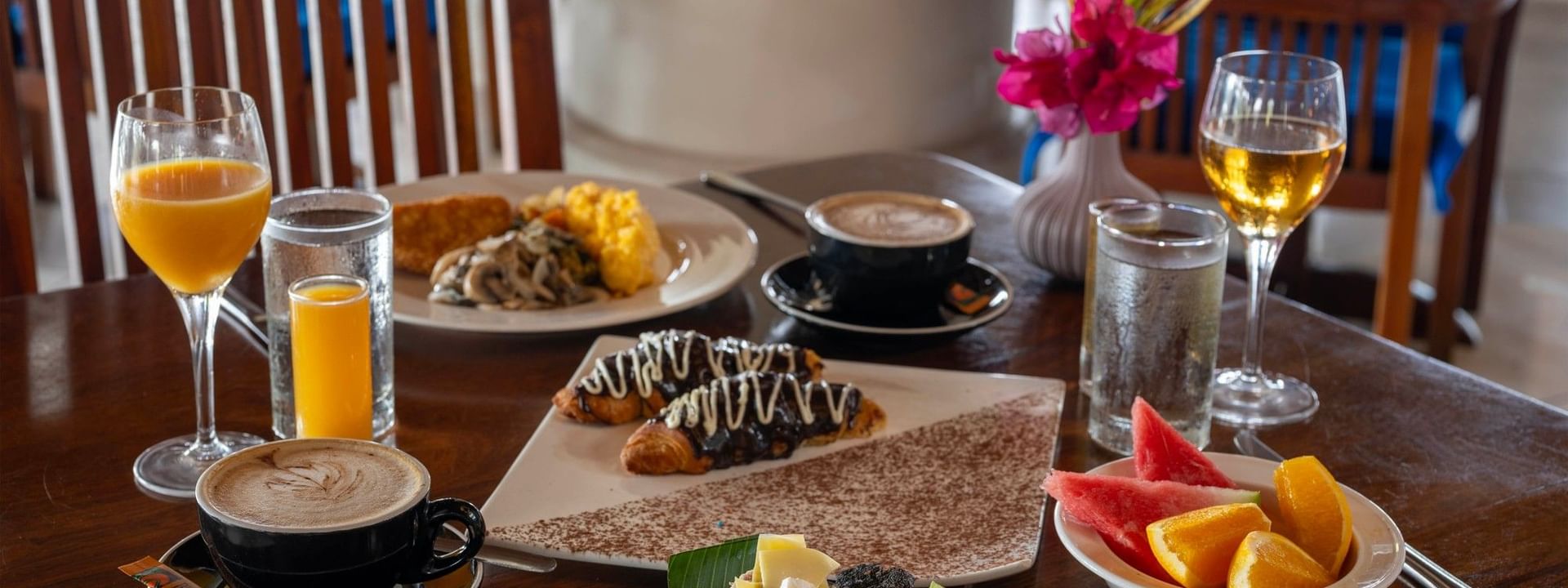 Assorted breakfast dishes on a wooden table at Lagoon Terrace Restaurant in Efate at Warwick Le Lagon - Vanuatu.