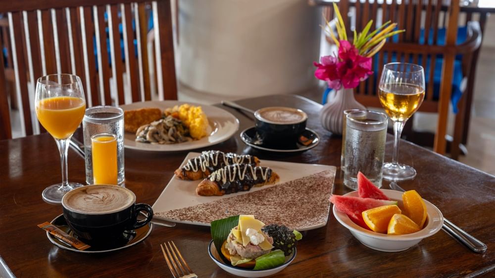 Assorted breakfast dishes on a wooden table at Lagoon Terrace Restaurant in Efate at Warwick Le Lagon - Vanuatu.