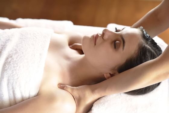 A lady relaxing on a treatment bed at Amatara Wellness Resort