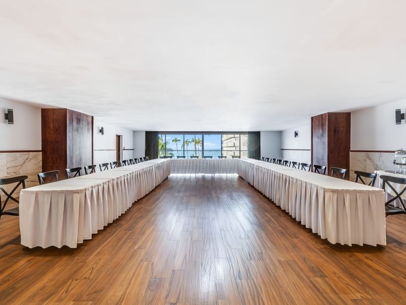 Large U-shaped conference table setup in Salón Azteca with wood floors and scenic ocean windows at Sunvivia Mazatlán