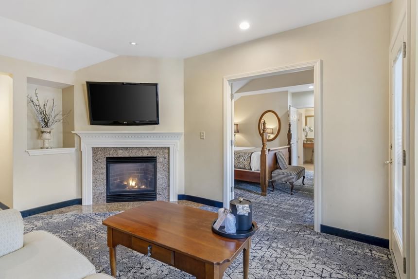 Living area with a TV and wooden stove at Ogunquit Collection