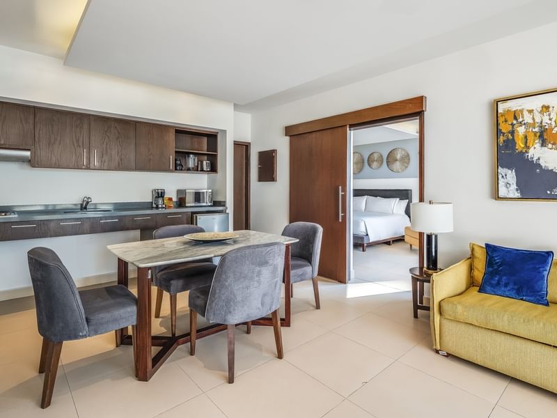 Villa Cora interior with a small kitchen, dining area, and a view into the bedroom at Sunvivia Mazatlán