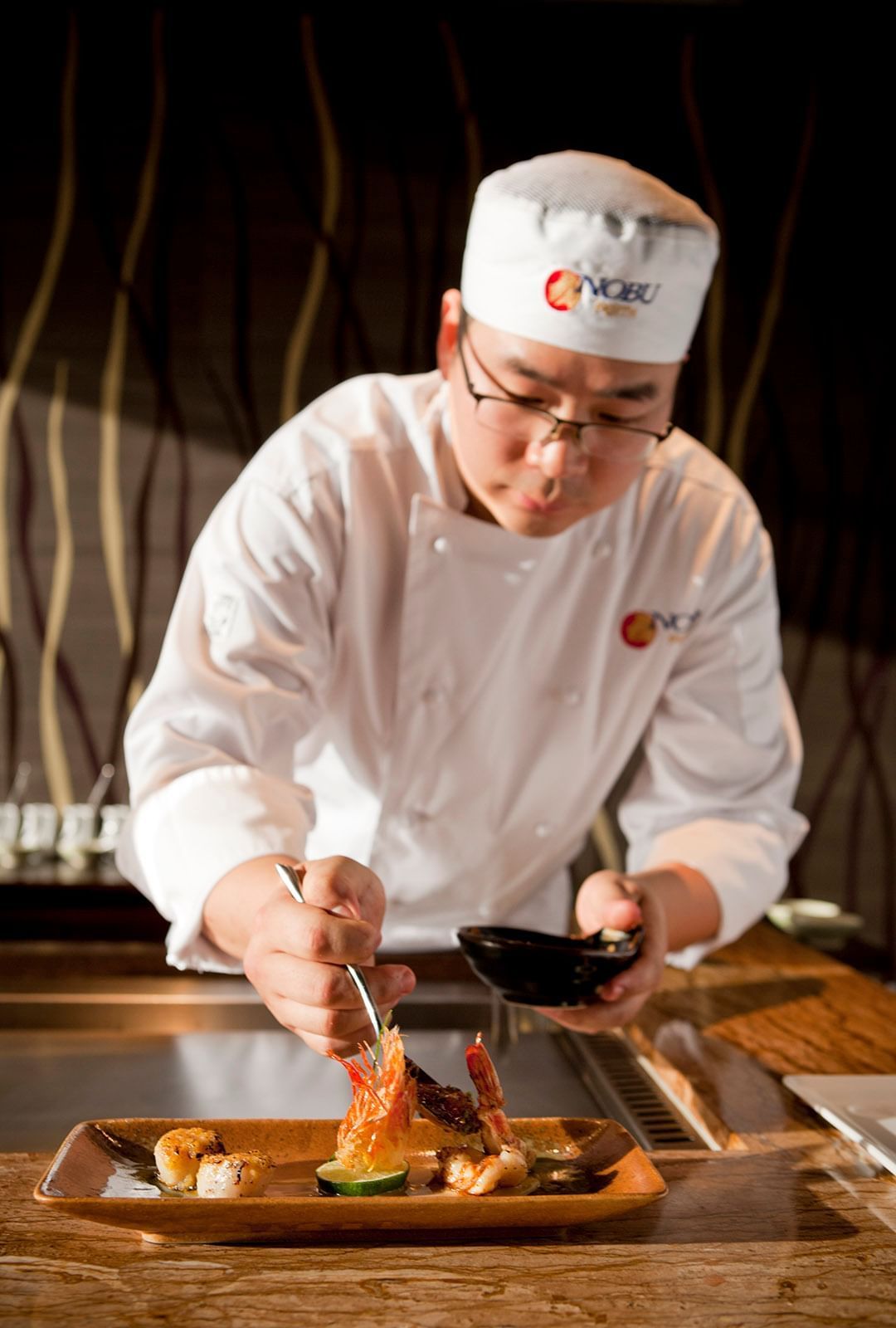 A chef preparing a meal at Crown Hotel Perth