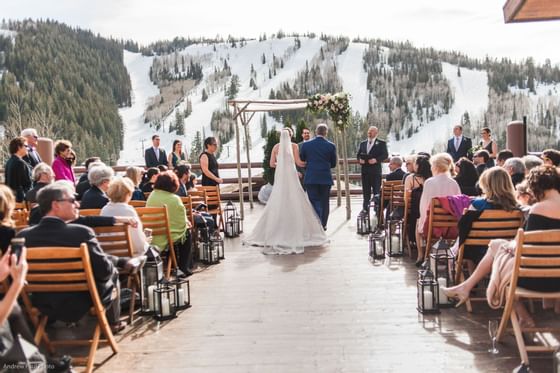 Bride & groom taking vows by the aisle at Stein Eriksen Lodge