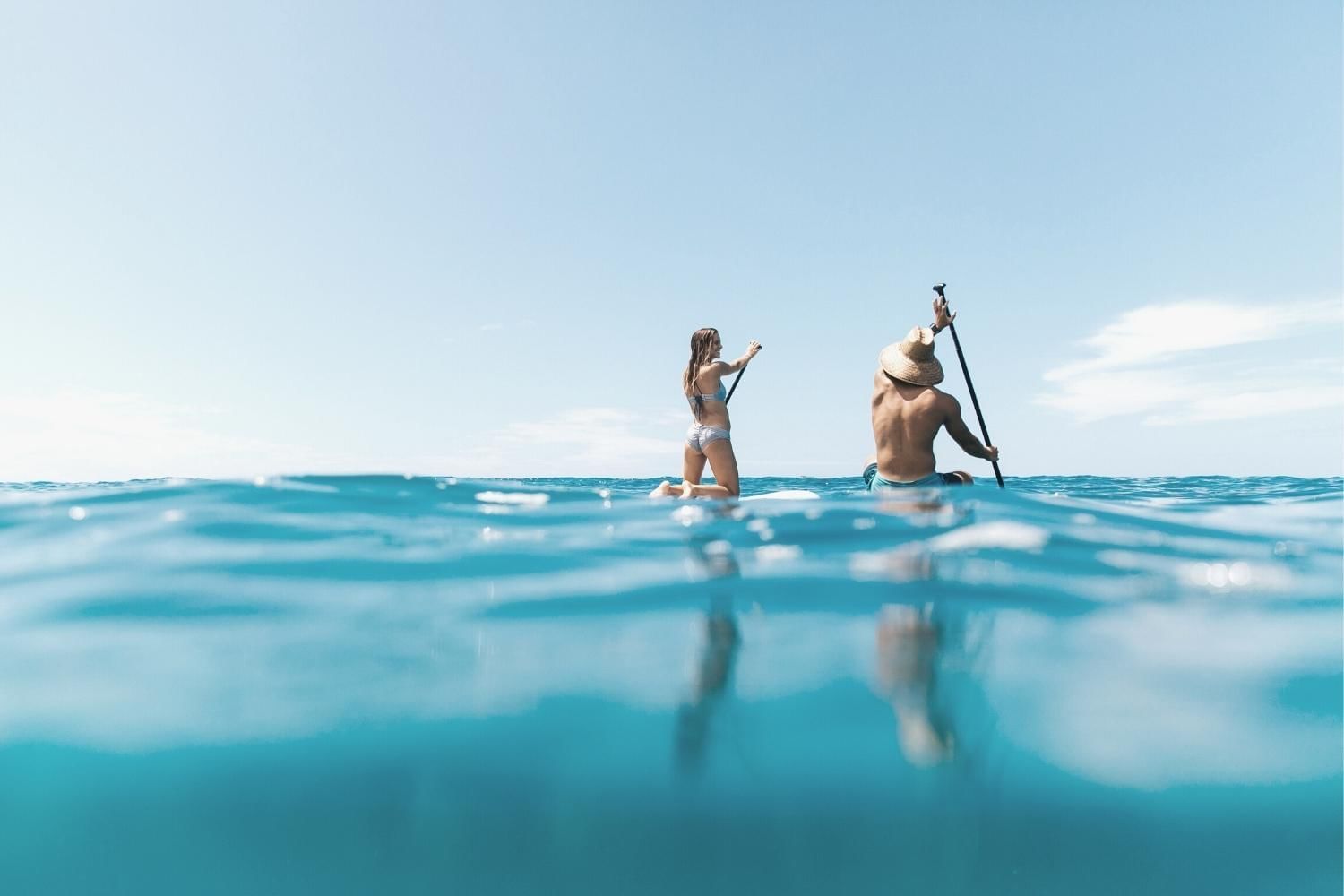 Two paddleboarders sitting in the ocean near Waikiki Resort Hotel by Sono
