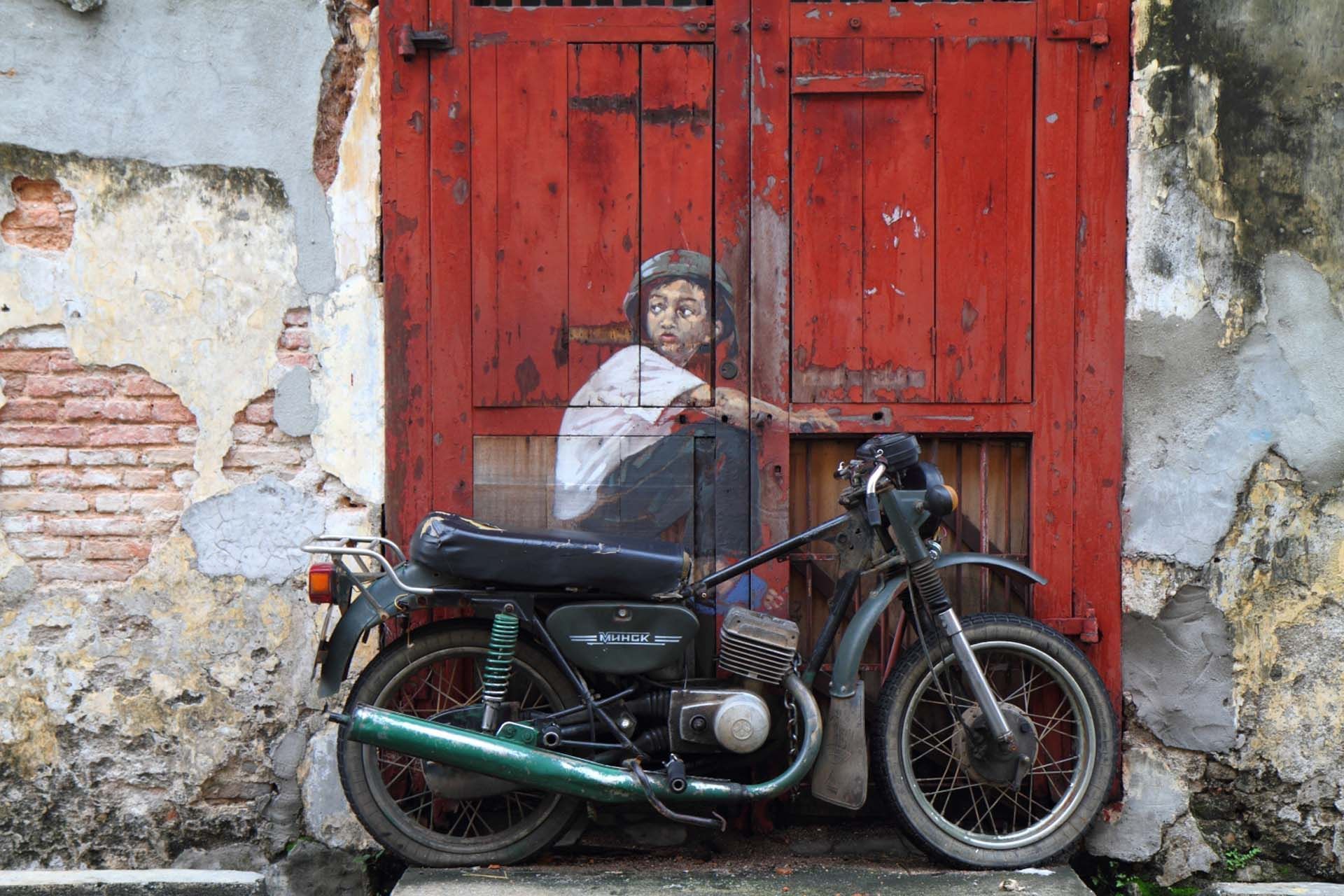 A popular street art mural in Penang featuring a boy on a motorcycle near Cititel Express Penang