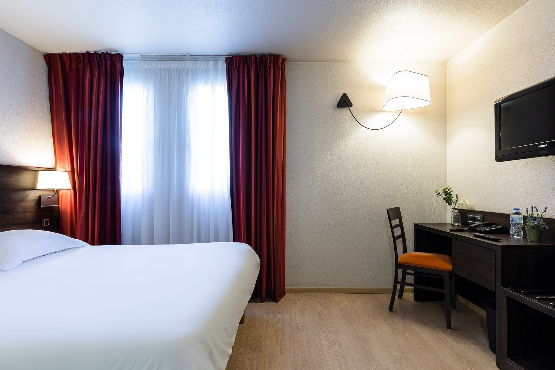 Lit king-size et bureau dans une chambre à l'Escale Oceania Brest Aéroport