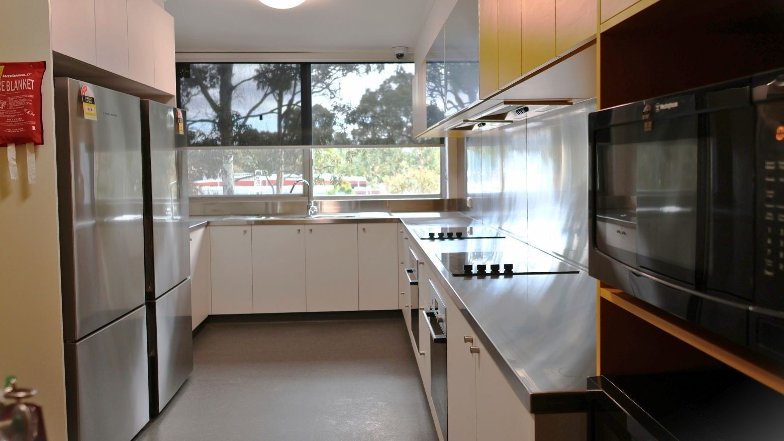 Modern kitchen with stainless steel appliances and white cabinets.