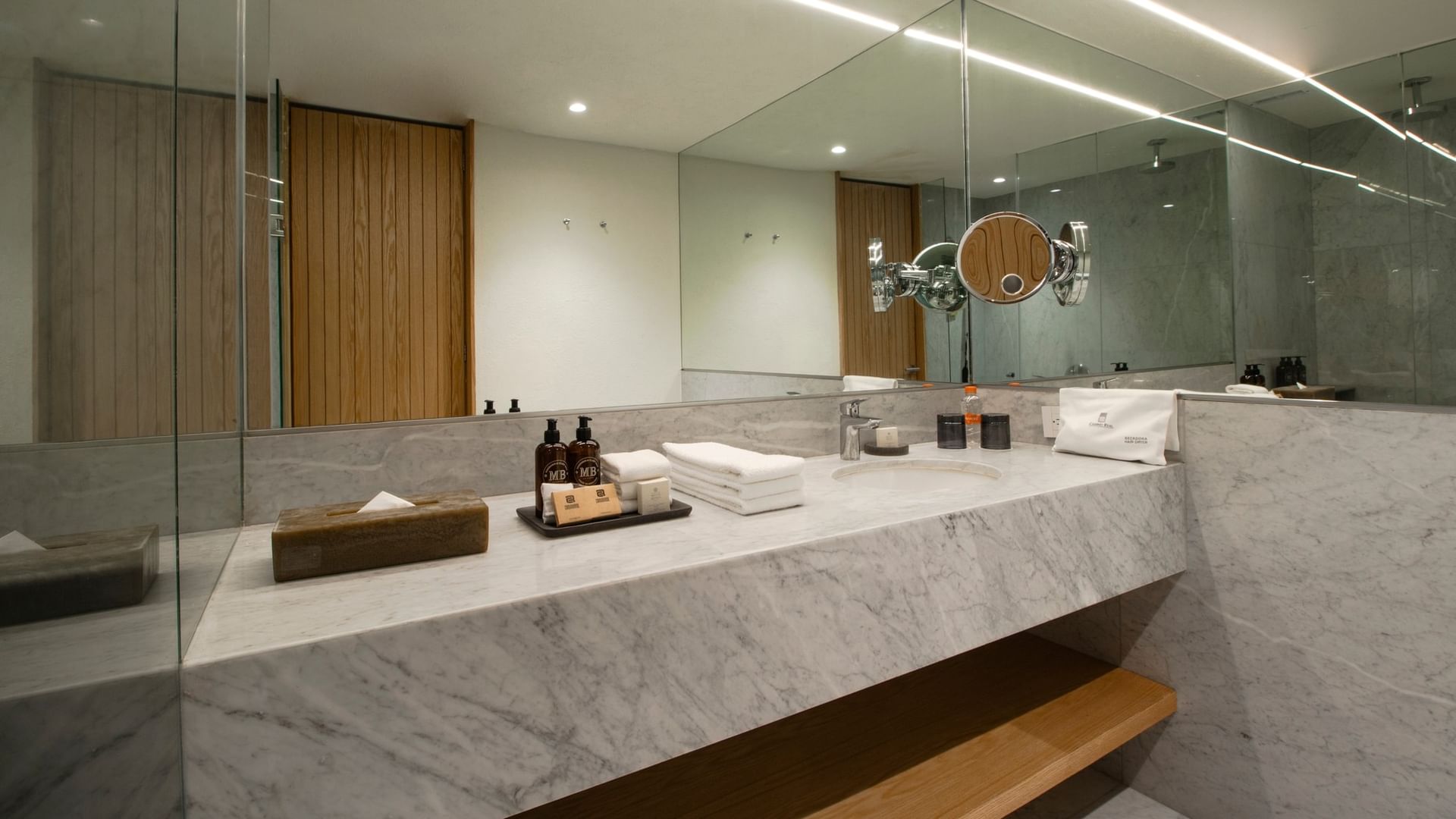 Baño elegante con mármol, espejo grande y productos de baño en la habitación De Lujo Superior King del Camino Real Polanco México.