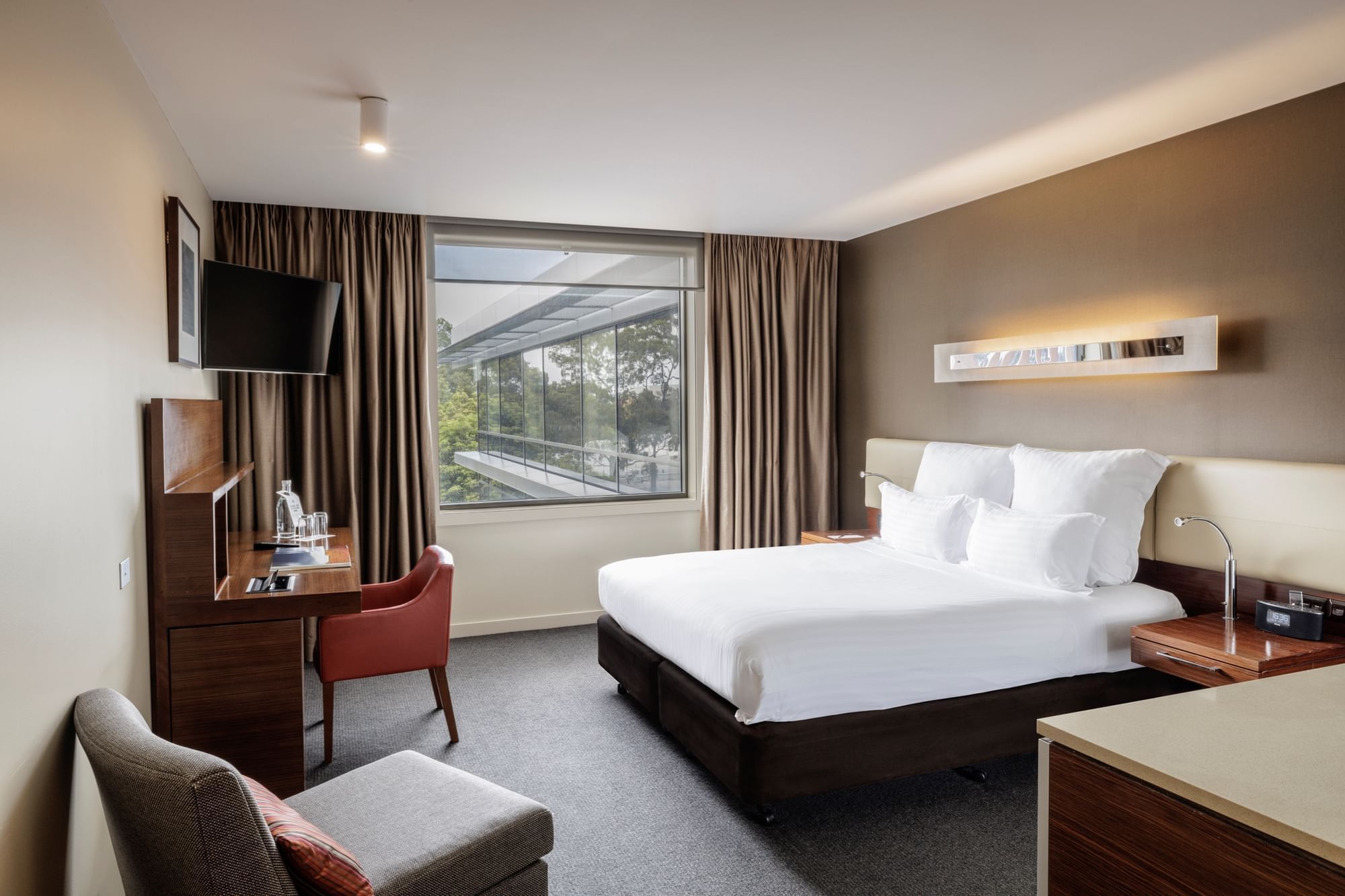 TV with workdesk facing bed by the window in Pullman Superior King Accessible Room 351 at Pullman Sydney Olympic Park