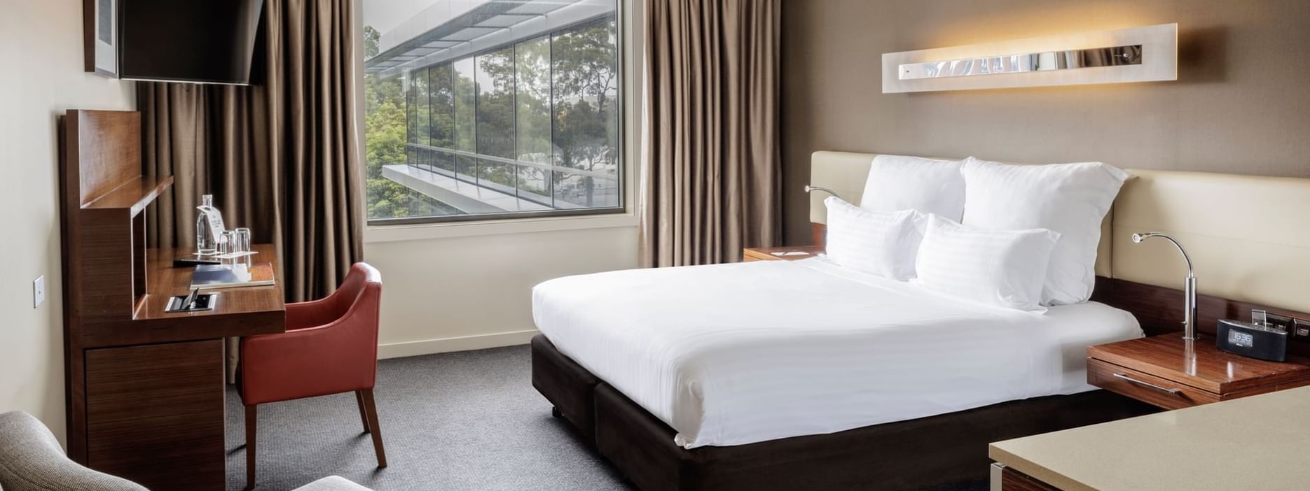 TV with workdesk facing bed by the window in Pullman Superior King Accessible Room 351 at Pullman Sydney Olympic Park