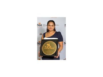 A lady holding a TAAVIC award at Amora Hotel Melbourne