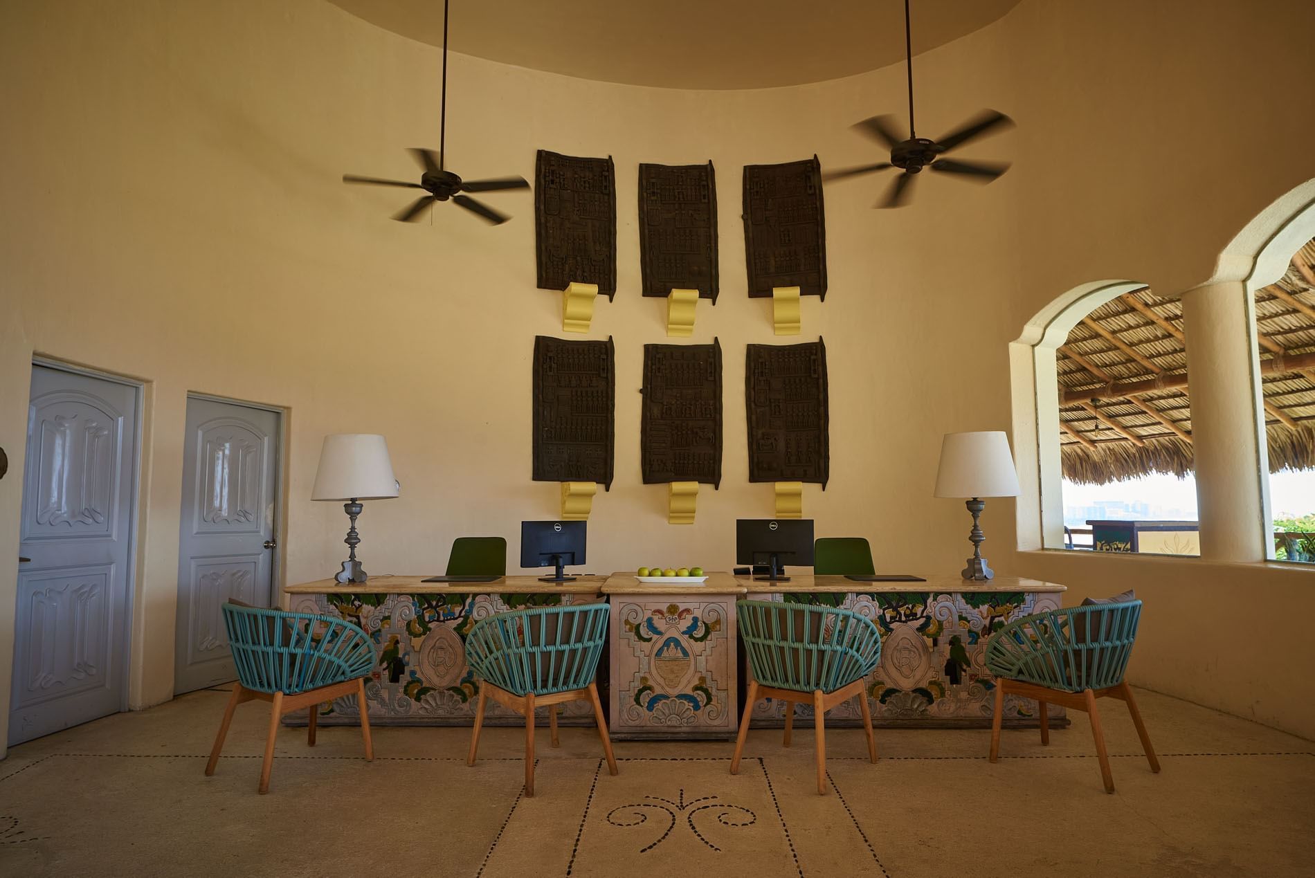 Front desk showing colorful woven chairs and artistic wall hangings in a circular room at Quinta Real Acapulco