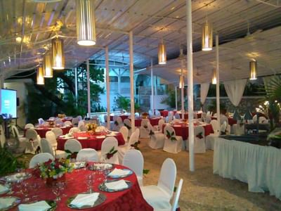 Olivia Room & Terrace with red-clothed tables and white chair covers under string lights at Hotel Montana Haiti