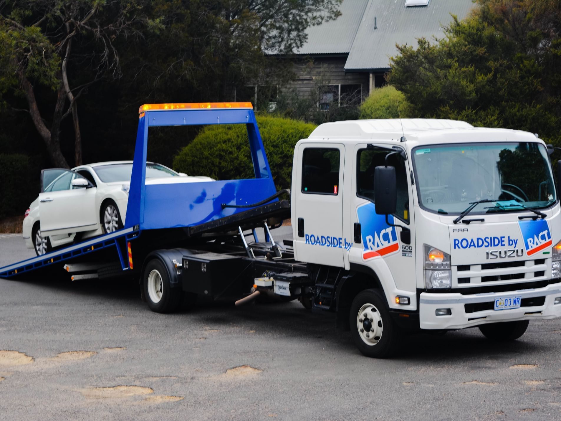 Close-up on a tow truck carrying a car near Freycinet Lodge