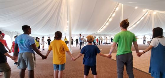 People holding hands in a circle at Honor's Haven