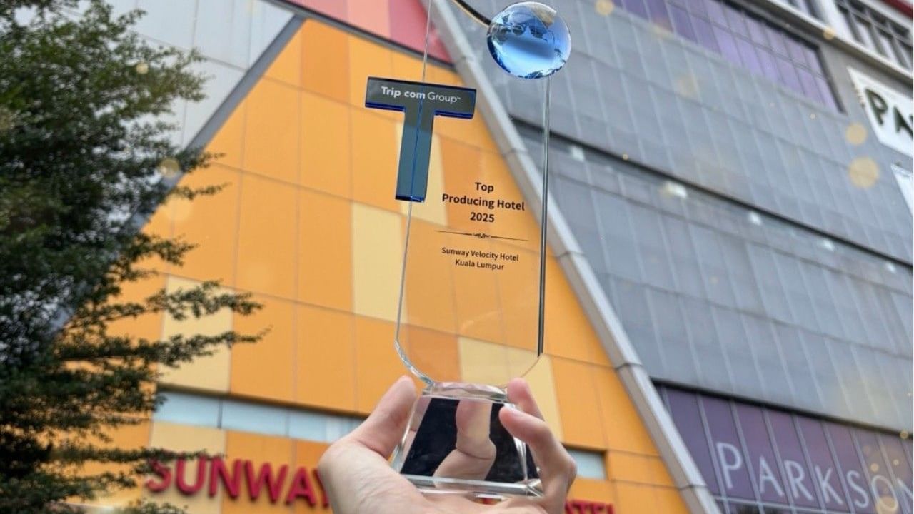 Hand holding a glass award titled 