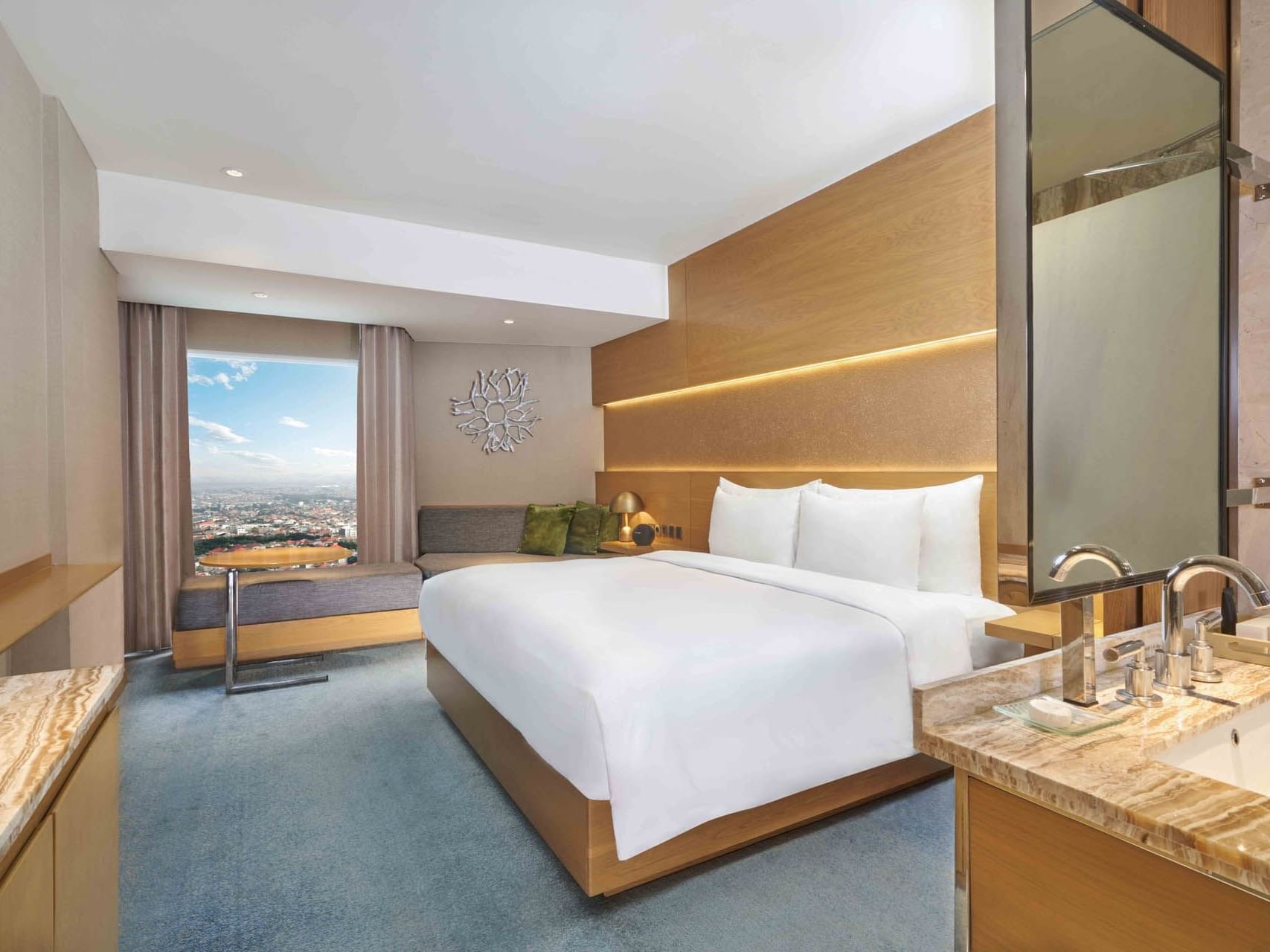 Queen bed & living area of select room in Vasa Hotel Surabaya