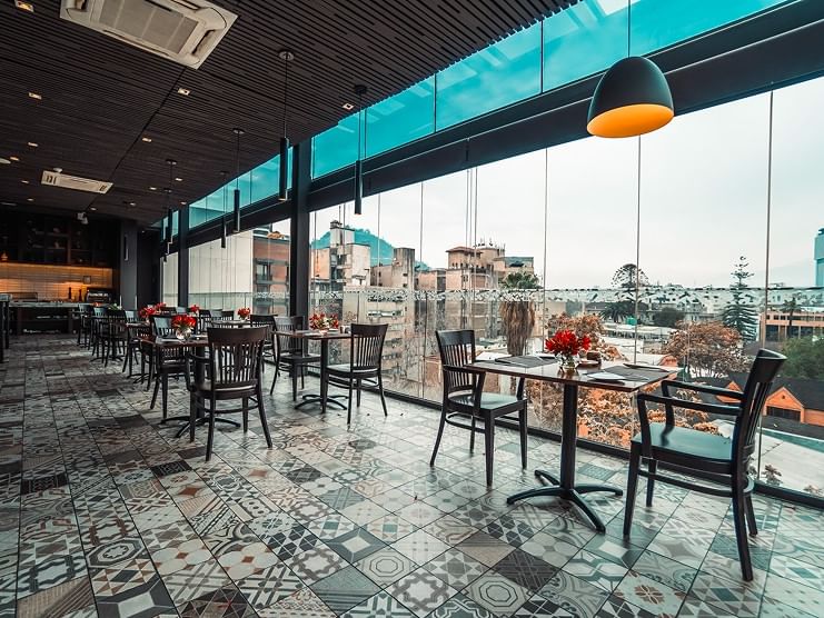 Restaurante Punto Ocho con amplios ventanales, mesas decoradas y vista urbana en Cumbres Lastarria, Santiago