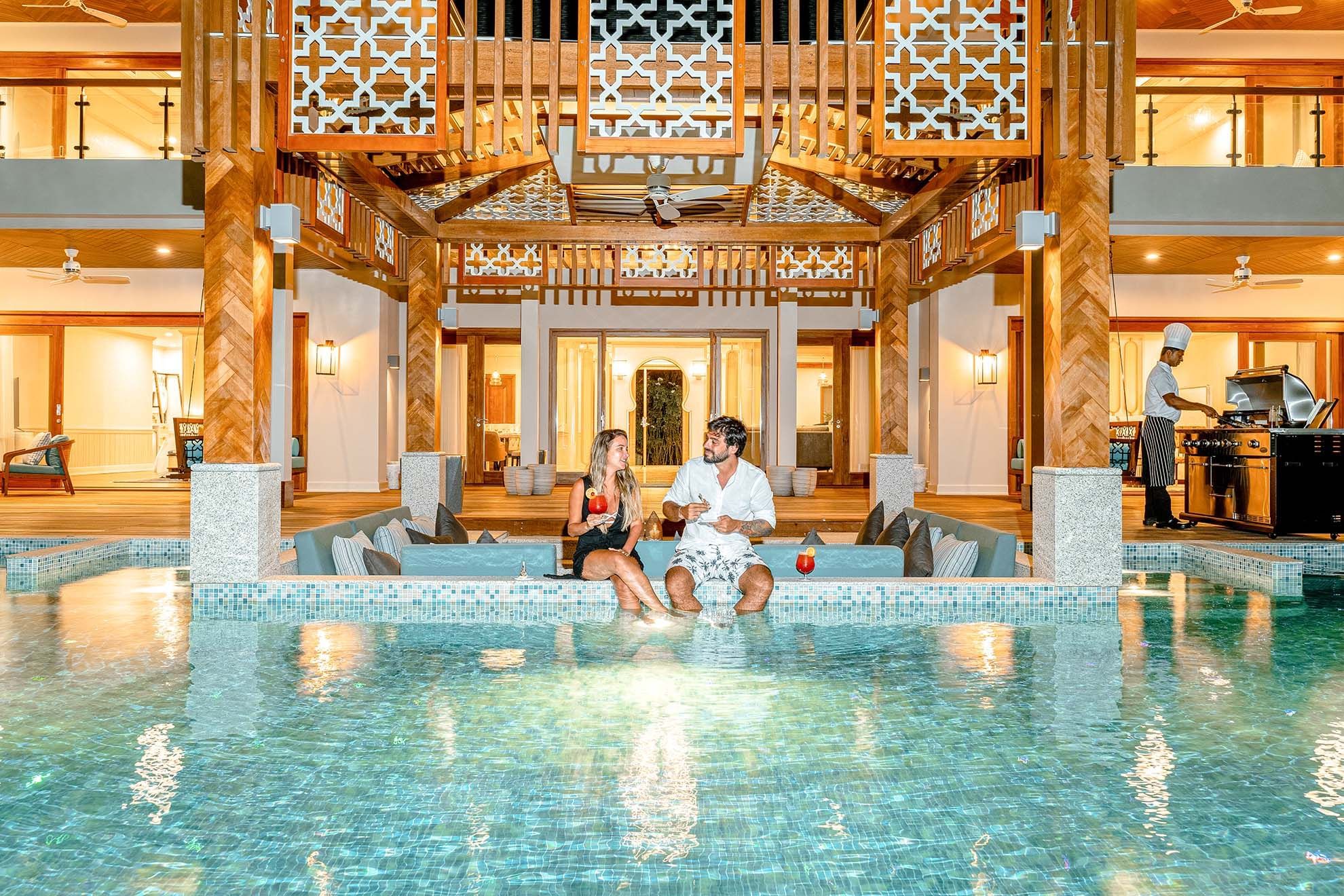 A couple lounging in the pool at The Signature Collection