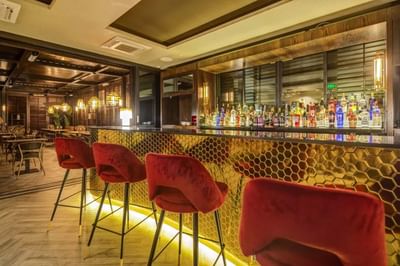 Liquor bottles lined by the counter in Bar Vistandes with a warm ambience at Hotel Nodo