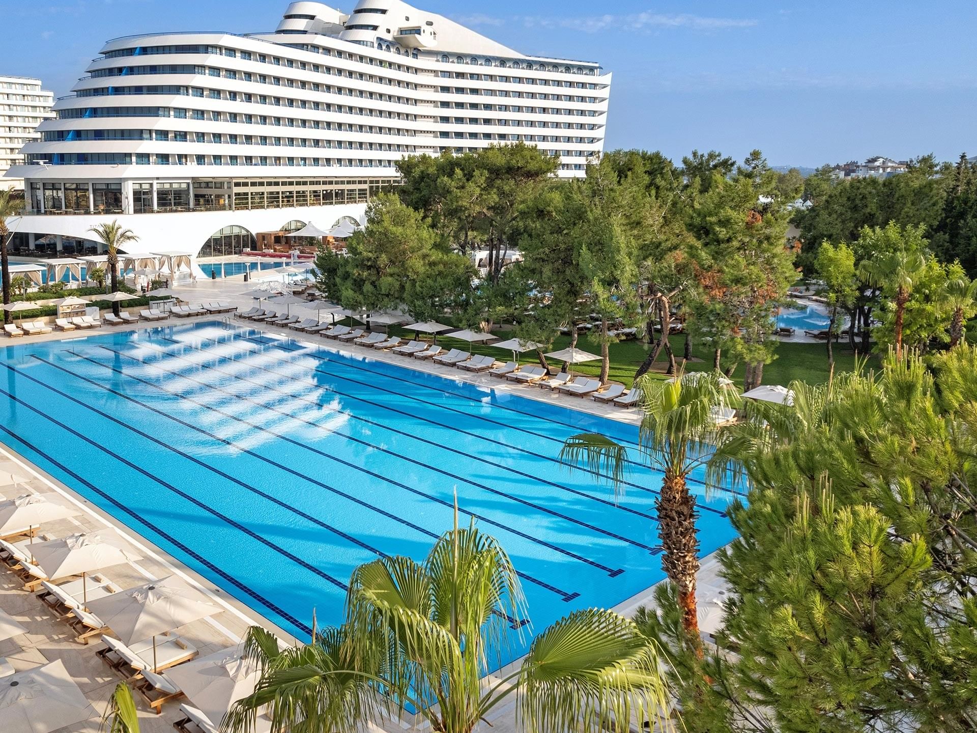 High-angle view of Olympic Pool and the hotel building at Titanic Deluxe Lara on a sunny day
