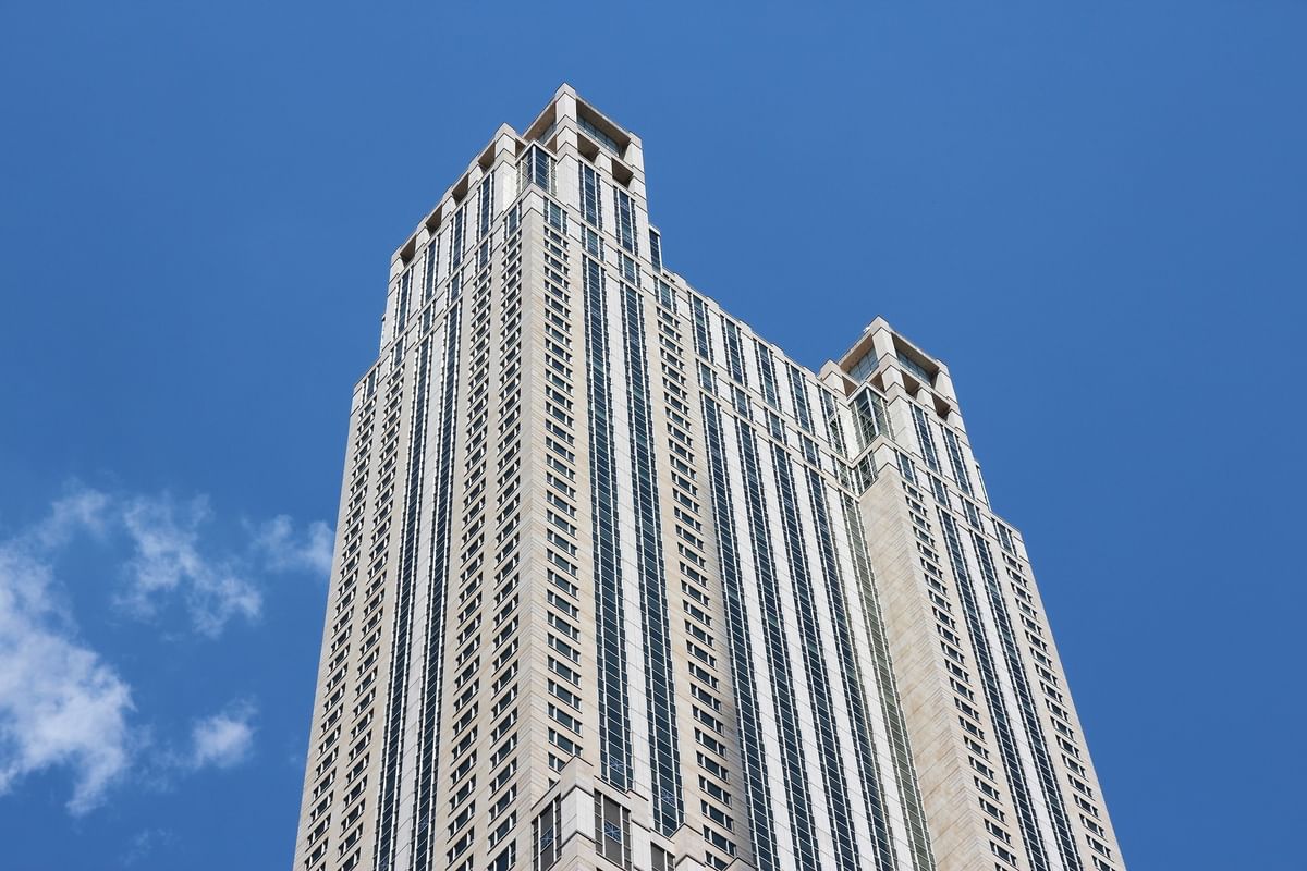 Tall modern skyscraper with numerous windows under a blue sky at Warwick Allerton Chicago Redesign