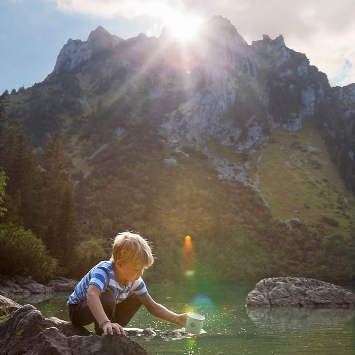 A boy playing in the lake near Falkensteiner Hotel Montafon