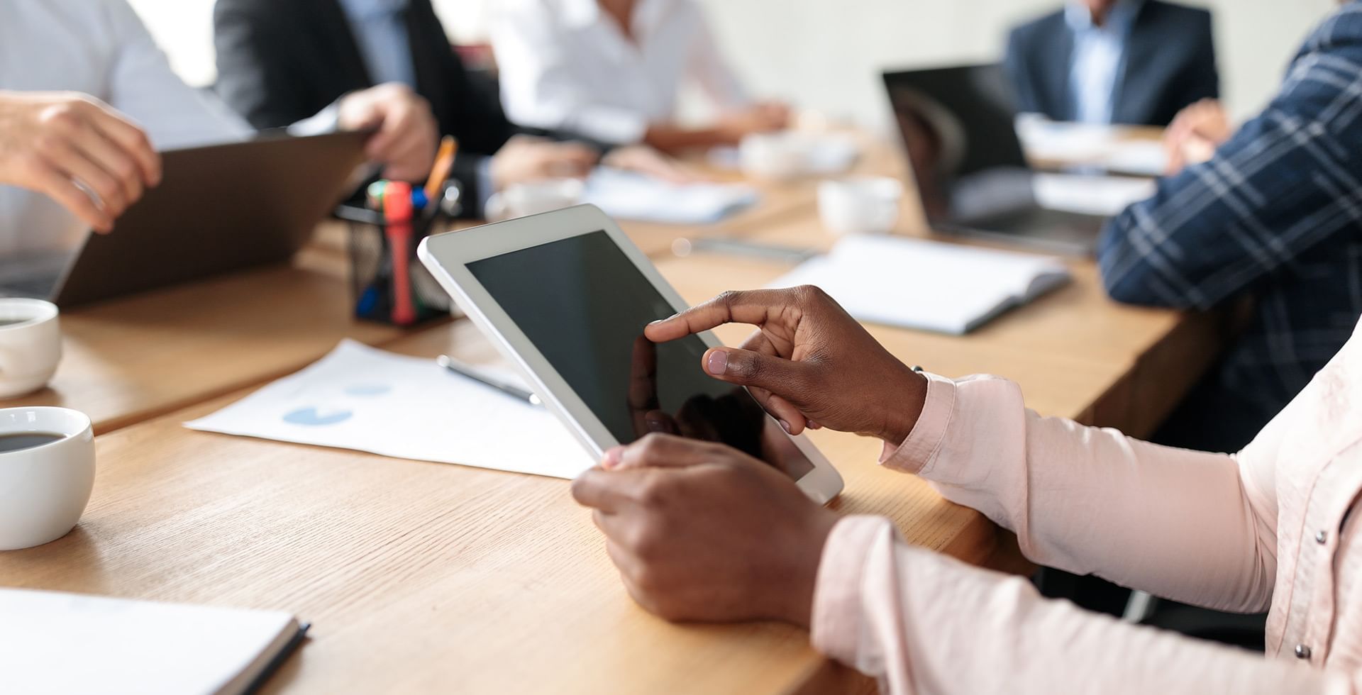 A woman holding a tablet in a meeting at Coast Fort St.John