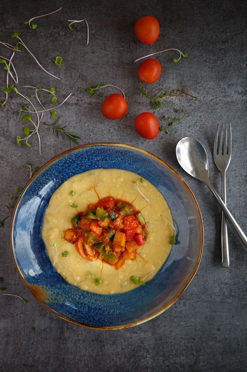 A bowl of creamy polenta with tomatoes served in Elevate at The Terraces Resort & Spa