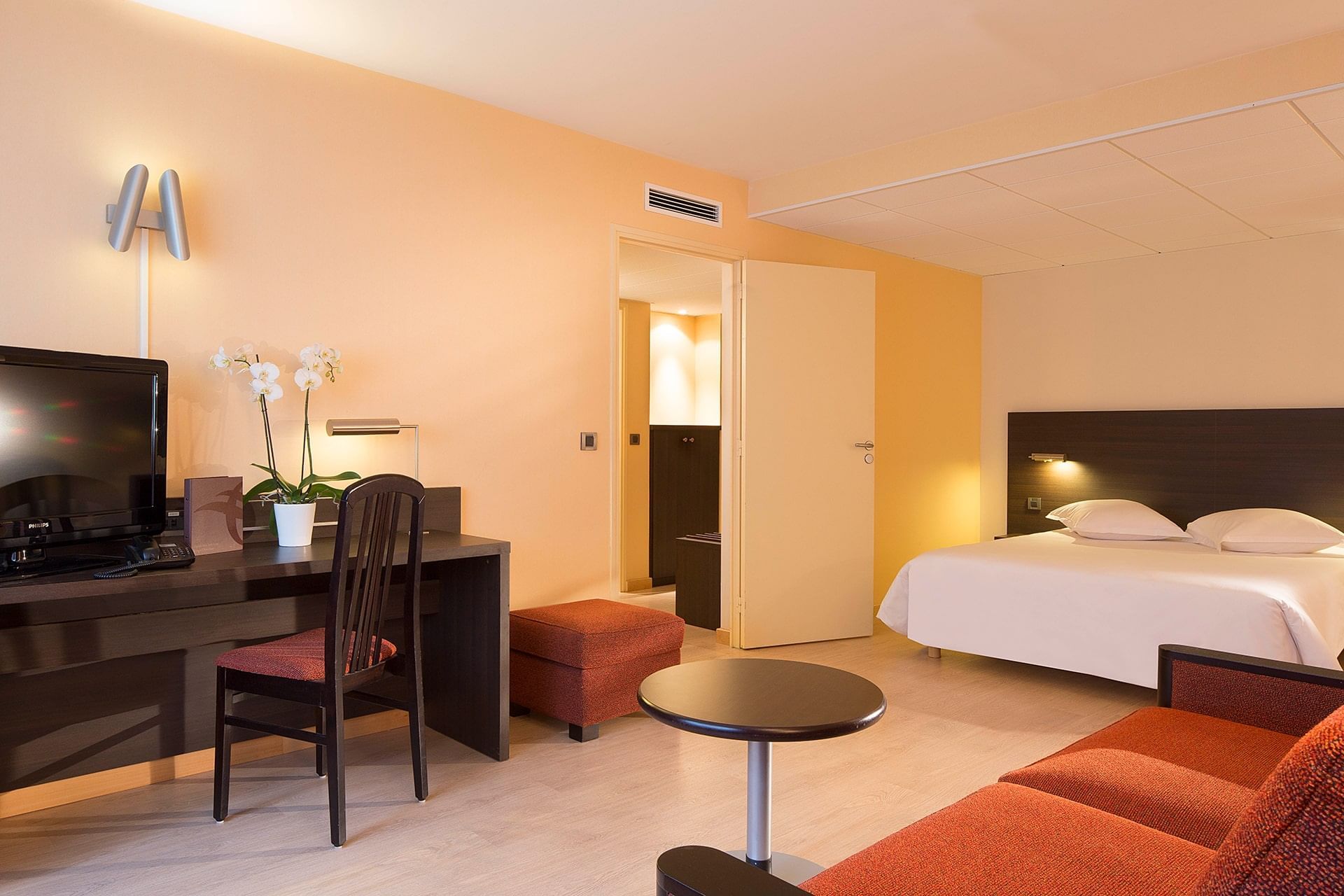 Lit king-size et bureau dans une chambre à l'Escale Oceania Brest Aéroport