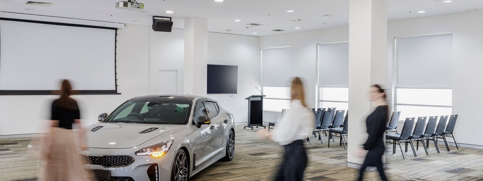 Silver car on display in the Parklands Room with people at Novotel Sydney Olympic Park