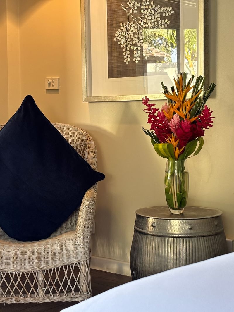 Wicker chair with pillow and flower vase on metal barrel table in Efate Pool Villa at Warwick Le Lagon Vanuatu.
